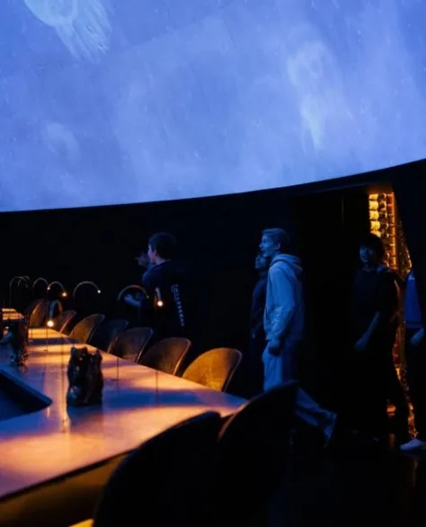 Guests entering Alchemist's dome under a deep blue oceanic projection